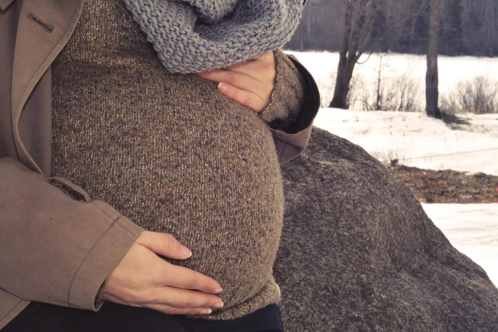 Zwangere vrouw draagt comfortabele en stijlvolle zwangerschapsmode met stretchbroek en tunica top